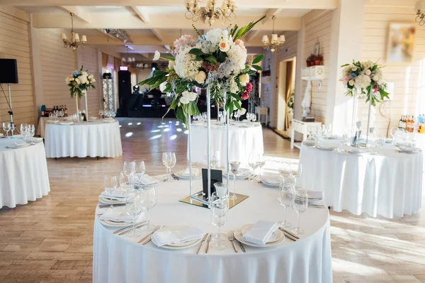 Een prachtige vaas bloemen op een tafel in een luxe restaurant. Bruiloft decoraties — Stockfoto
