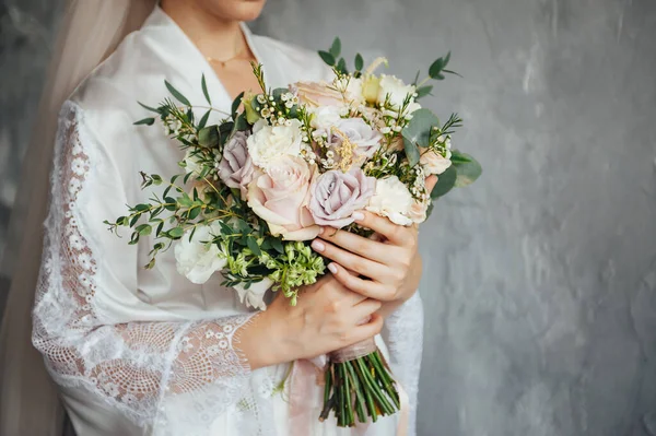 Krásná svatební kytice v rukou nevěsty na šedé zdi na pozadí — Stock fotografie