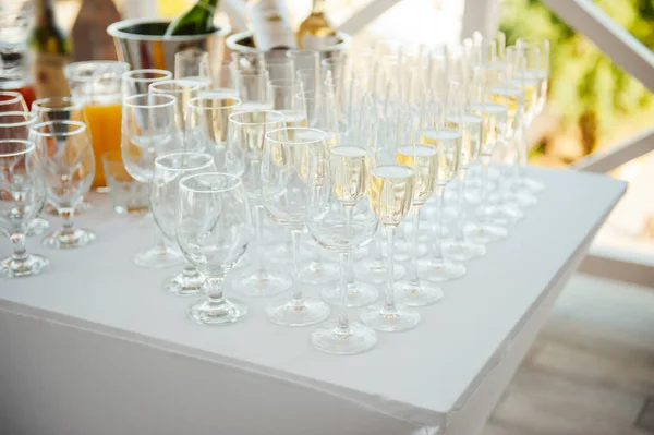 Glaasjes champagne op het banket, witte mousserende wijn in wijnglazen, feestelijke stemming — Stockfoto