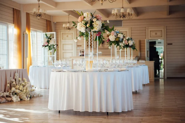 Ένα όμορφο βάζο με λουλούδια σε ένα τραπέζι σε ένα πολυτελές εστιατόριο. Διακόσμηση γάμου — Φωτογραφία Αρχείου