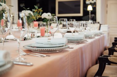 Lüks restoran. Lüks içecekler, beyaz masalar, misafirler için servis tabakları ve bardaklar.