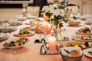 Lüks restoran. Lüks içecekler, beyaz masalar, misafirler için servis tabakları ve bardaklar.