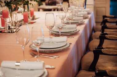 Lüks restoran. Lüks içecekler, beyaz masalar, misafirler için servis tabakları ve bardaklar.