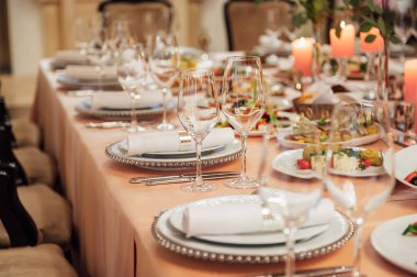 Lüks restoran. Lüks içecekler, beyaz masalar, misafirler için servis tabakları ve bardaklar.