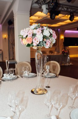 Lüks restoran. Lüks içecekler, beyaz masalar, misafirler için servis tabakları ve bardaklar.