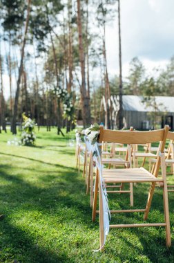 Dışarıda çok güzel bir tören. Ormanda klasik düğün. Çiçekli metal kemer.