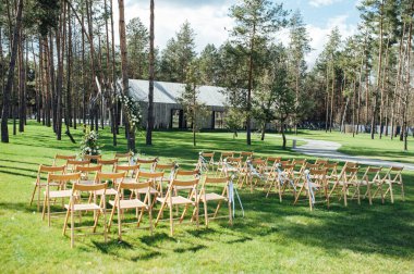 Dışarıda çok güzel bir tören. Ormanda klasik düğün. Çiçekli metal kemer.