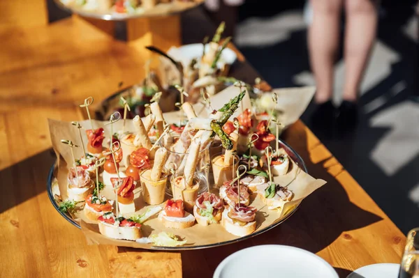 Sanduíches, canapés e bolos na mesa festiva. Uma grande variedade de lanches — Fotografia de Stock