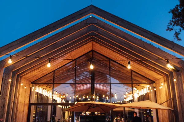 Modern ahşap bir evin arka planına sahip avluda akşam aydınlatması