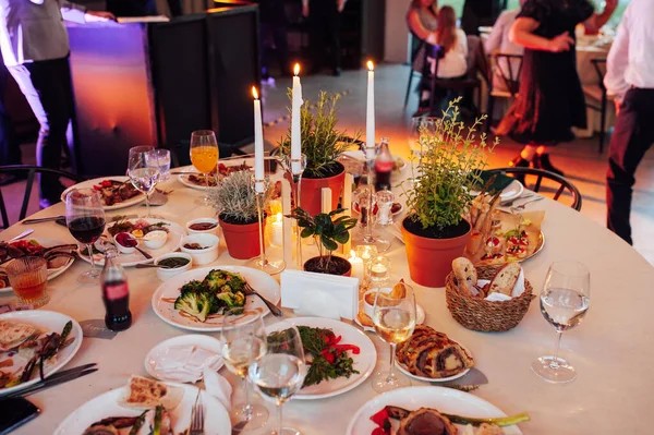 Flower and candle decoration for a wedding against the background of dancing guests — Stock Photo, Image