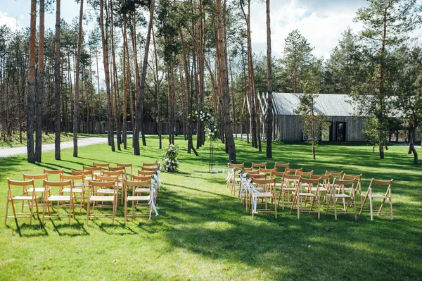Cerimônia externa muito bonita. casamento clássico na floresta. Arco de metal com flores. — Fotografia de Stock