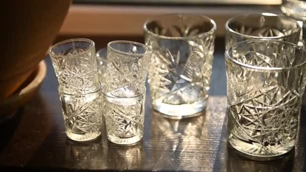 Beautiful luxury empty crystal glasses stand on the table against the background of the sun rays — Stock Video