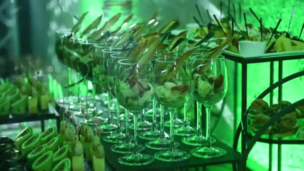 Uma seleção variada de coquetéis e lanches no buffet na festa noturna. Luz de néon verde — Vídeo de Stock