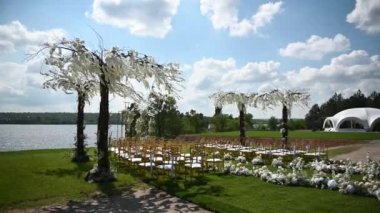 Nehir kıyısında, salkımlı ağaçlı yeni evliler için düğün töreni için özel kemer.