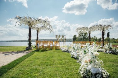 Nehir kıyısında, salkımlı ağaçlı yeni evliler için düğün töreni için özel kemer.