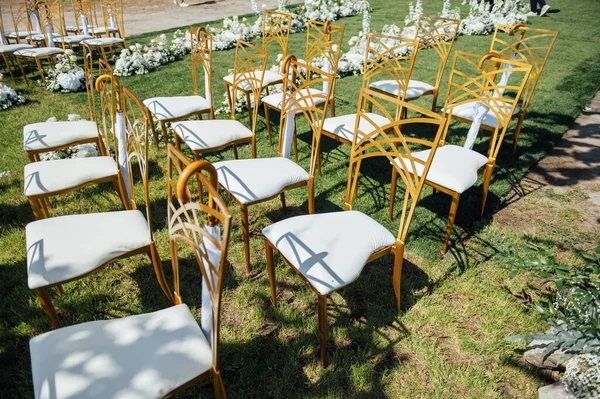 Feestelijke trouwceremonie. Paraplu aan een lege stoel hangen — Stockfoto