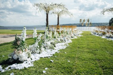 Nehir kıyısında, salkımlı ağaçlı yeni evliler için düğün töreni için özel kemer.