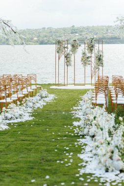 Nehir kıyısında, salkımlı ağaçlı yeni evliler için düğün töreni için özel kemer.