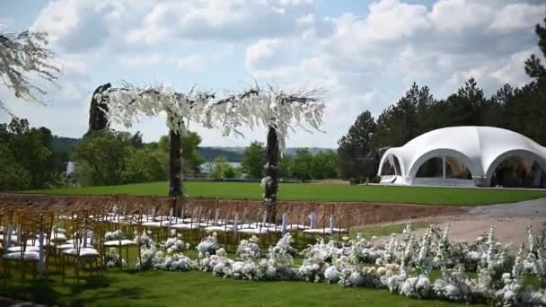 Arco de prêmio de cerimônia de casamento de recém-casados na margem do rio com árvores de wisteria — Vídeo de Stock