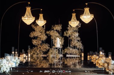 Düğün kemerinin arka planında beyaz-pembe güzel düğün pastası