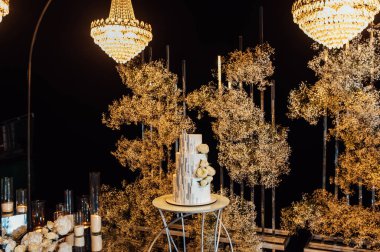 Düğün kemerinin arka planında beyaz-pembe güzel düğün pastası