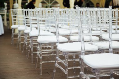 Güzel bir düğün töreninde cam sandalyeler sıraya dizilir.
