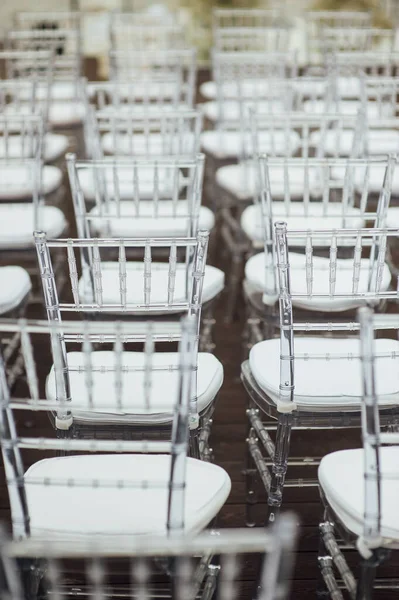 Glass chairs stand in a row in a beautiful wedding outing ceremony — Stock Photo, Image