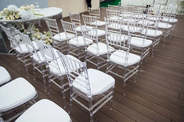 Glass chairs stand in a row in a beautiful wedding outing ceremony — Stock Photo, Image