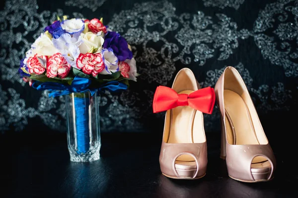 Close-up van bruids boeket van rozen, bruiloft bloemen voor de ceremonie op het bed in een hotelkamer met witte schoenen — Stockfoto