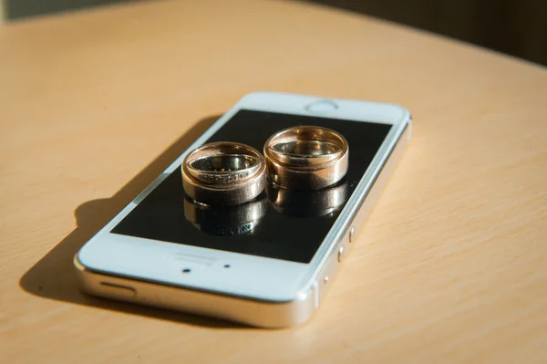 wedding rings laying on cell phone screen