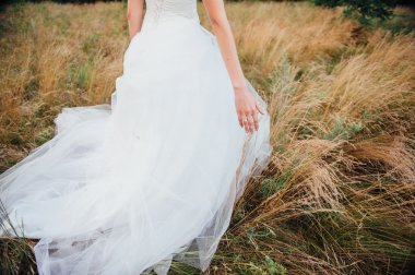 İhale güzel gelinin zarif beyaz düğün elbise portre üzerinde eller