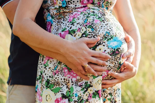 Homem com mulher grávida abraçando e acariciando barriga — Fotografia de Stock