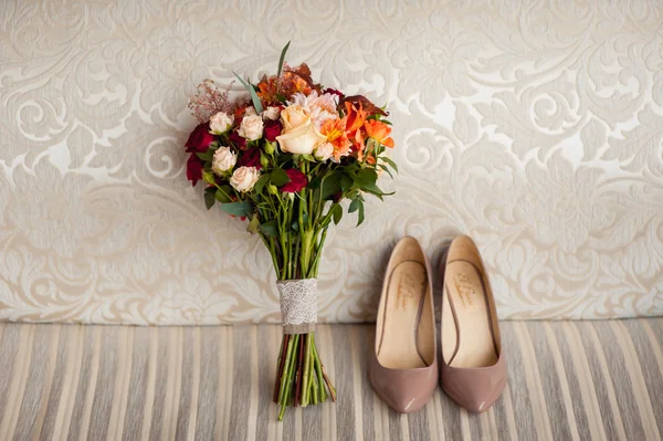 Trouwschoenen voor boeket en bruidsmeisje op bruin mat — Stockfoto