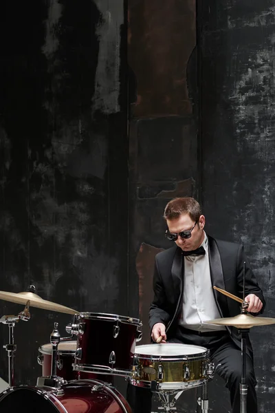 Güneş gözlüğü ve davul çalmaya uymak yakışıklı adam