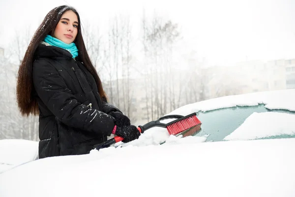 Vacker ung kvinna att ta bort snö från hennes bil — Stockfoto