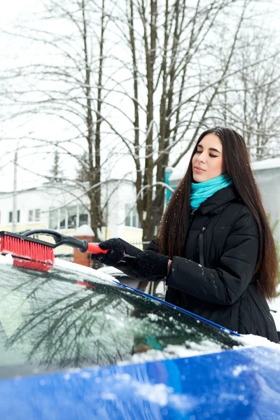 Mulher bonita removendo neve de seu carro — Fotografia de Stock