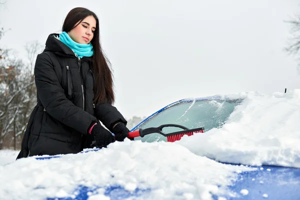 Vacker ung kvinna att ta bort snö från hennes bil — Stockfoto