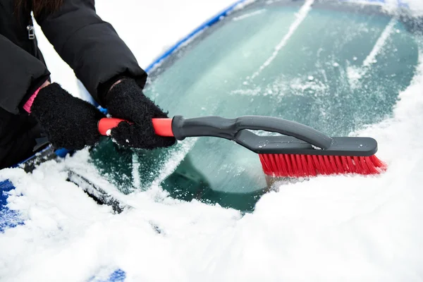 Ta bort snö med borste från bil vindrutan i vinterdag — Stockfoto