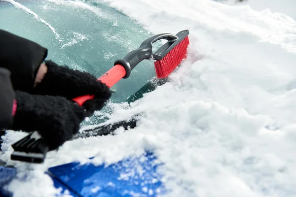 Sneeuw met borstel worden verwijderd uit de auto voorruit in de winterdag — Stockfoto