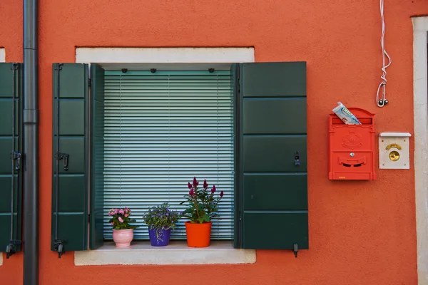 Традиционное окно жилого дома с открытыми ставнями и цветочным горшком в Венице, Италия — стоковое фото