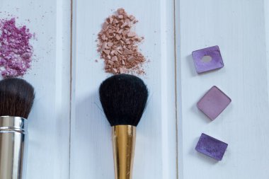 kadın aksesuarlar kozmetik. Makyaj fırçaları ve ahşap arka plan üzerinde ezilmiş göz farı 