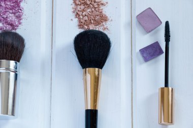 kadın aksesuarlar kozmetik. Makyaj fırçaları ve ahşap arka plan üzerinde ezilmiş göz farı 