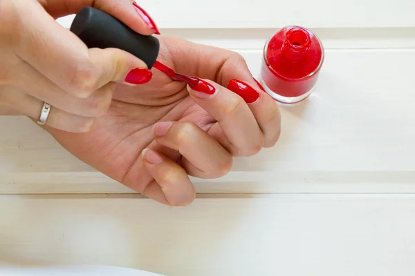 Mujer aplicando manicura de esmalte de uñas rojo. Mano femenina —  Fotos de Stock