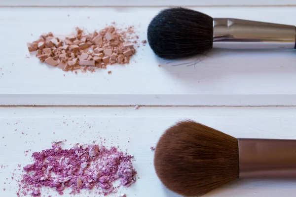 Accesorios cosméticos de las mujeres. Pinceles de maquillaje y sombra de ojos aplastada sobre fondo de madera —  Fotos de Stock