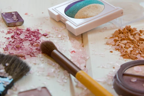 Accesorios cosméticos de las mujeres. Pinceles de maquillaje y sombra de ojos aplastada sobre fondo de madera —  Fotos de Stock