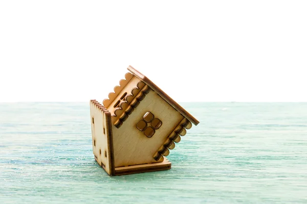Zabawka drewniany model domu jako symbol rodziny i koncepcji miłości na słoneczne stare niebieskie drewniane tło kupno domu, kredyt hipoteczny, naprawa, stabilność do góry nogami — Zdjęcie stockowe