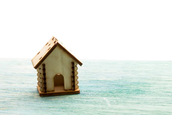Giocattolo casa modello in legno come simbolo famiglia e amore concetto su soleggiato vecchio sfondo di legno blu acquisto di una casa, mutuo, riparazione, stabilità — Foto Stock