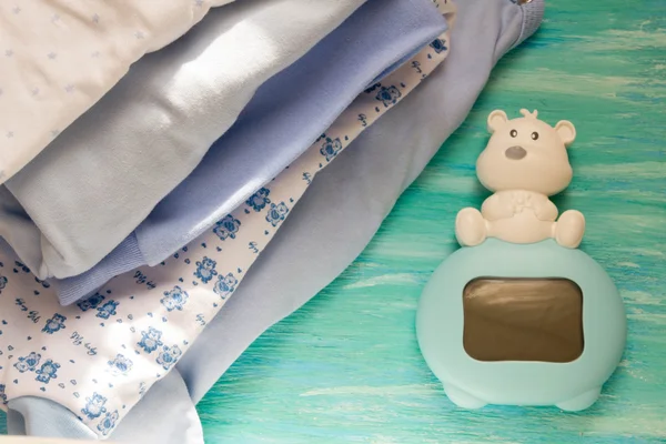 Ropa de bebé recién nacido y azul sobre fondo de madera habitación de los niños, los accesorios de pila en la mesa Madre cuidado — Foto de Stock
