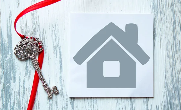 Icona della casa e le chiavi su sfondo di legno turchese, il simbolo per la costruzione, prestito, mutuo, proprietà o casa, eccellente per una casa per comprare vendere affitto, idee commerciali, annunci — Foto Stock