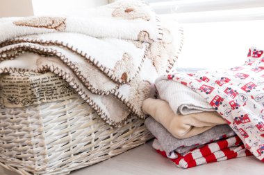 çocuk oyuncakları, çocuk bezi, Aksesuar tabloda gri ahşap arka plan üzerinde gri sepetle. Anne bakım. Çocuk Odası, yeni doğan çocuk için mavi elbise yığını